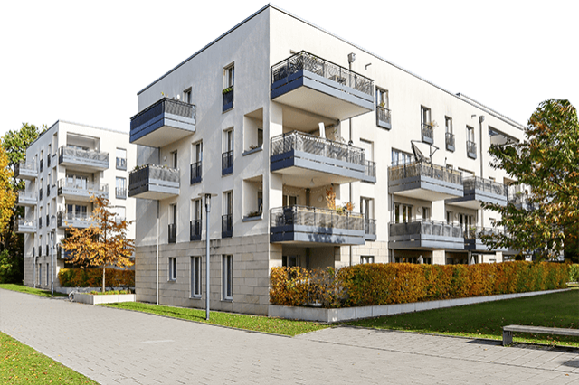 Moderne weiße Mehrfamilienhäuser mit Balkonen in gepflegter Wohngegend